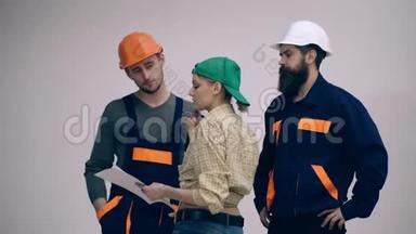 三位施工人员正在讨论施工方案.. 建设工程概念.. 两个戴头盔的女人